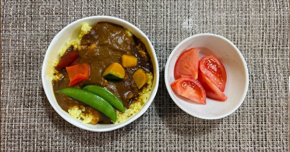 ごろっとチキンカレーにトマトを添えた写真
